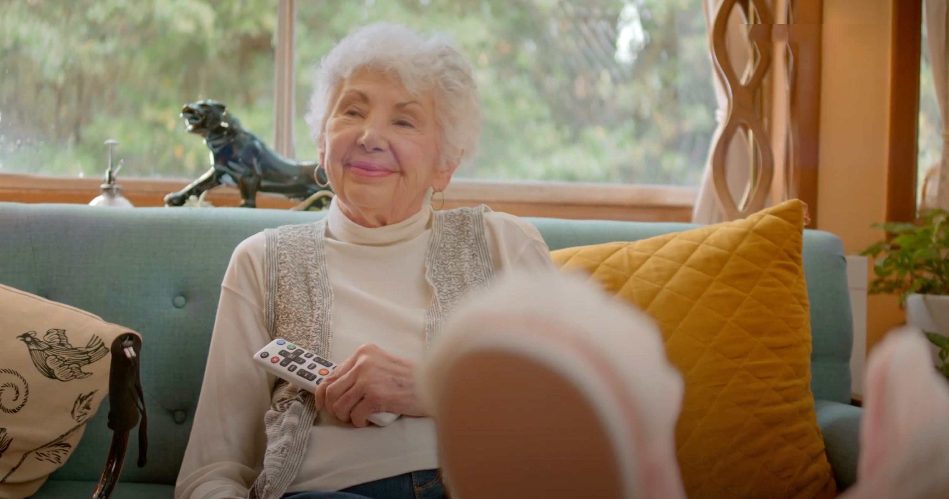 happy elderly woman holding the jubileetv remote for seniors